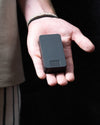 Matte Black mission pill box being held in someone's hand. 100% metal pill box that functions as a travel pill box. 