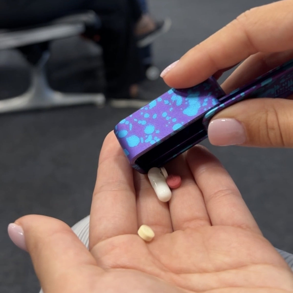 Pouring one day of pills from a Disco Splatter Ikigai case at an airport gate