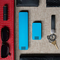 One Bahama Blue Weekly Pill Case and One Bahama Blue Travel Pill Case laying next to items for a ladies purse.
